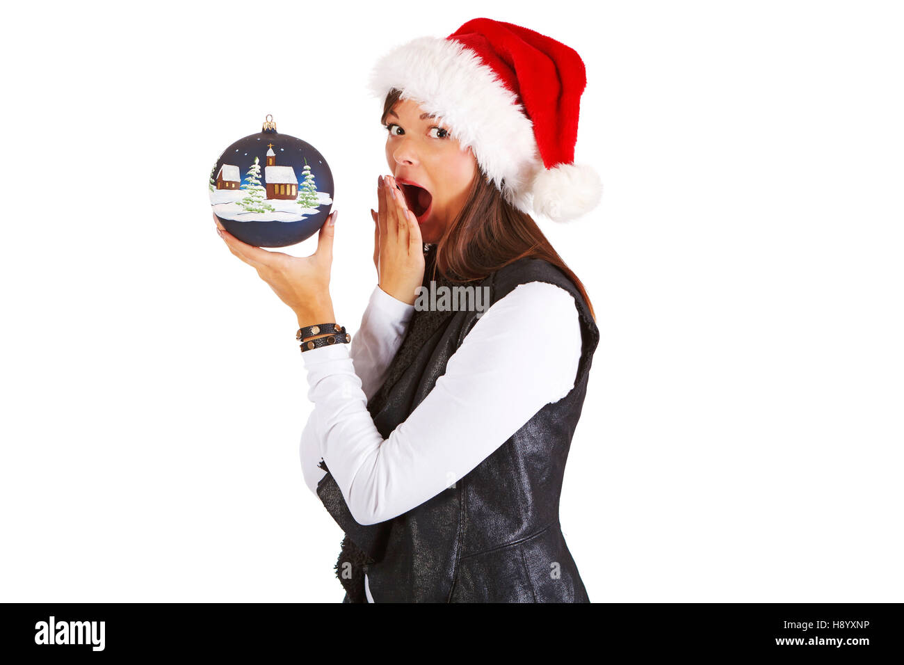 Ragazza sorridente in santa's hat, tenendo il natale Pallina, guardando la telecamera, vagare Foto Stock