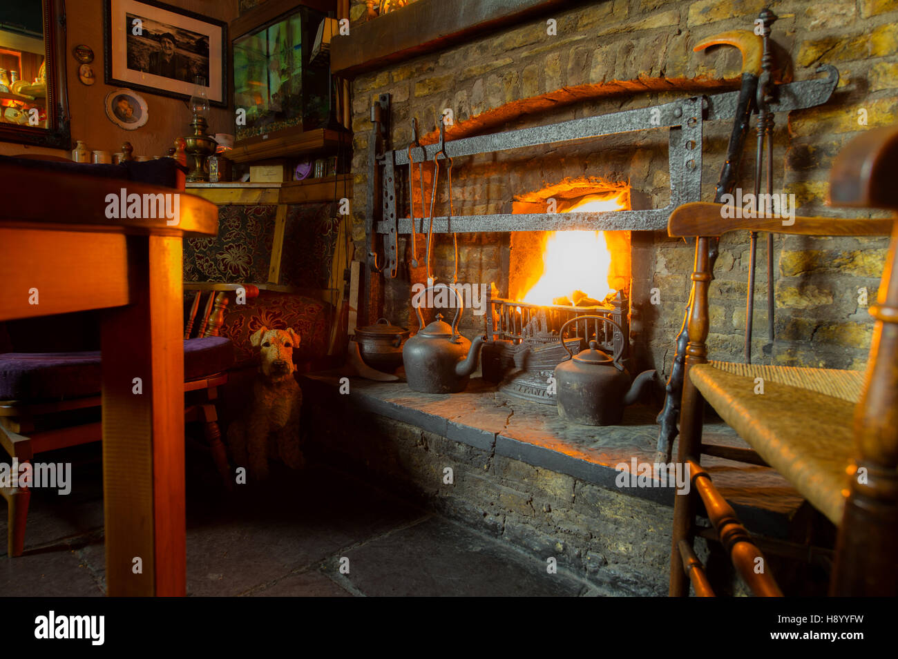 Camino in stile rustico con un fuoco illuminato in un pub di campagna in Irlanda. Foto Stock