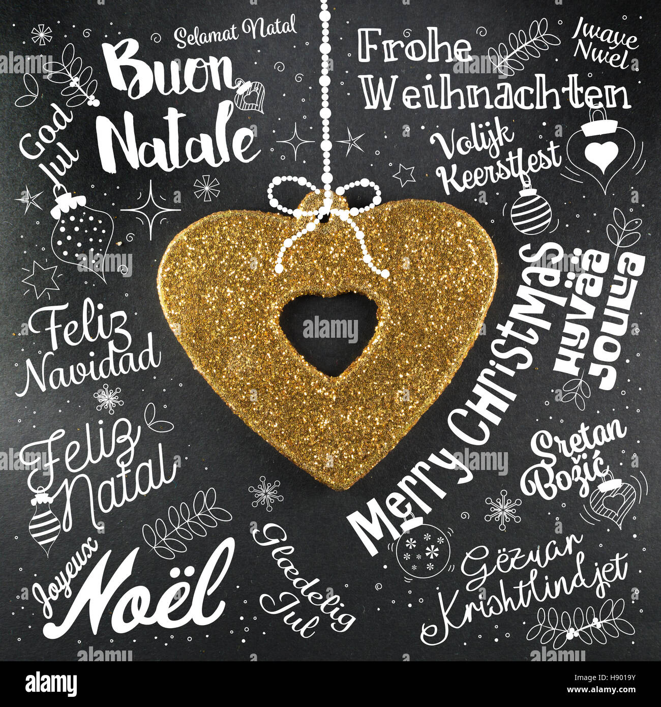 Buon Natale biglietto di auguri da tutto il mondo in diverse lingue con cuore d'oro, testo calligrafico e font di caratteri scritti a mano Foto Stock
