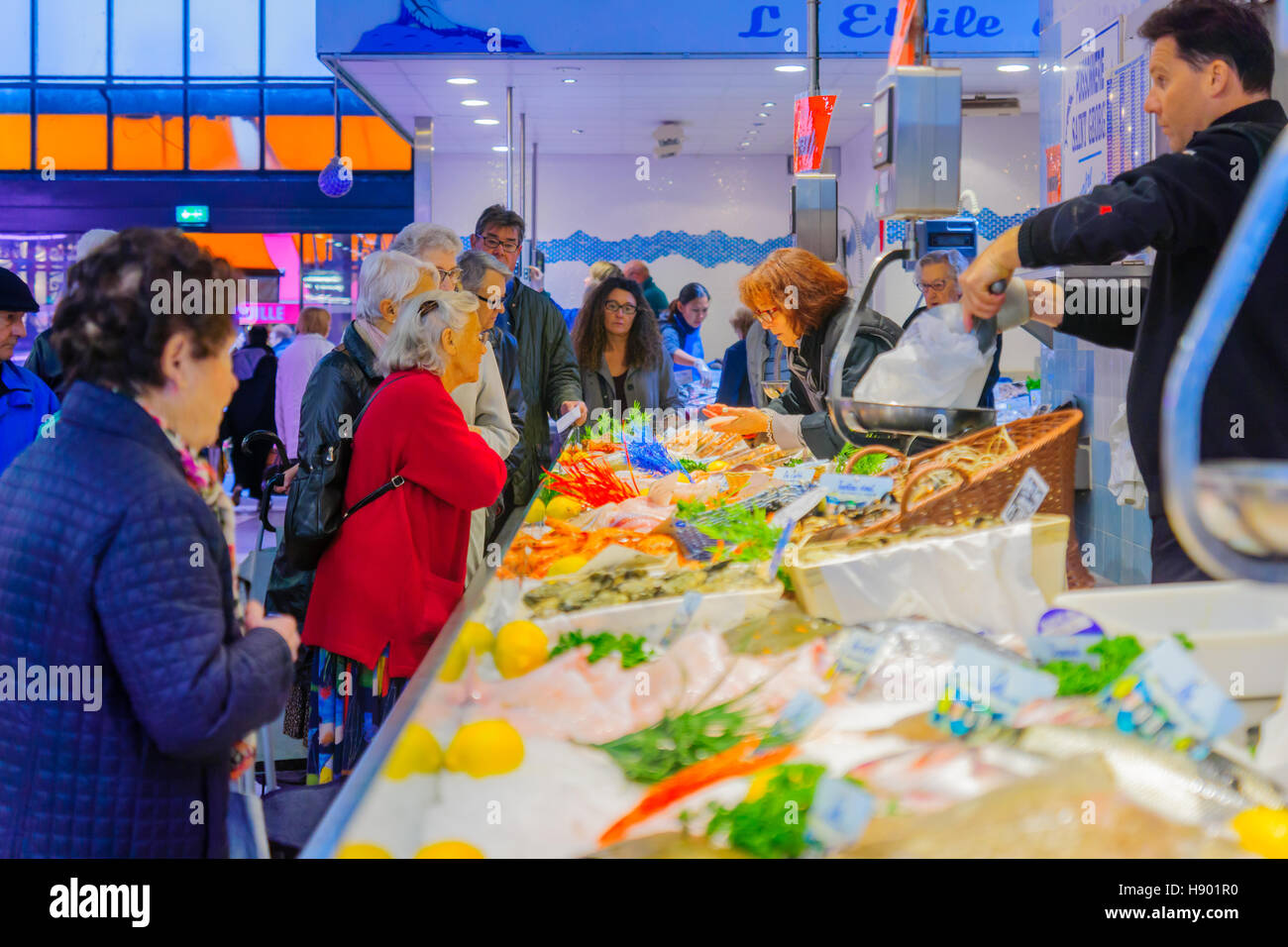 DIJON, Francia - 14 ottobre 2016: Scena di mercato con vari tipi di pesci e frutti di mare, i venditori e gli acquirenti, a Digione, Borgogna, Francia Foto Stock