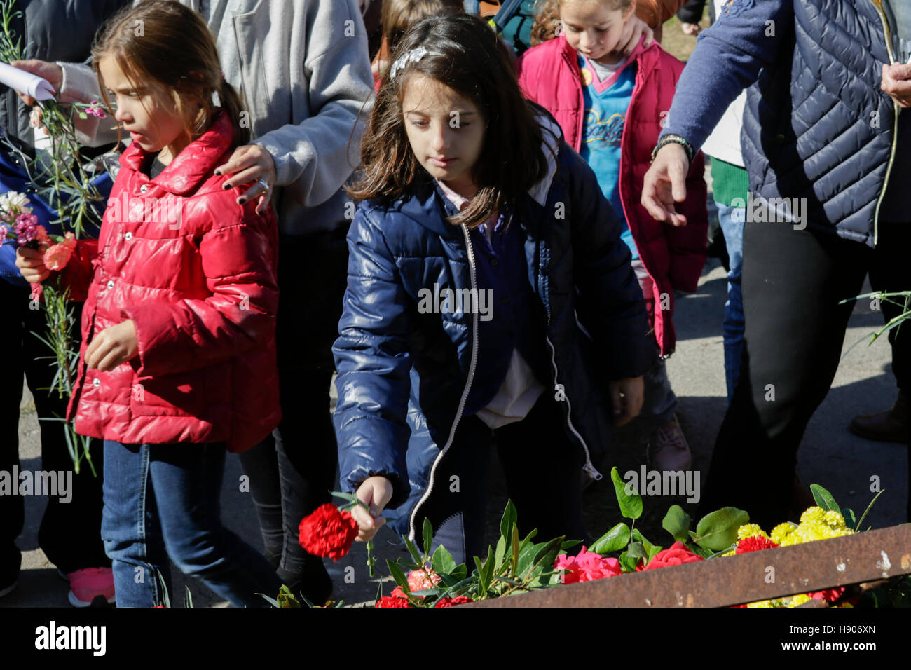 Atene, Grecia. 17 novembre 2016. Una ragazza getta fiori sulla parte superiore della porta originale che è stata schiacciata dalla vasca. La gente di Atene ha commemorato il 1973 il Politecnico di Atene uprising sul 17. Novembre, il giorno, la sollevazione era schiacciato dalla Giunta Greca. La rivolta è ampiamente considerato come l'inizio della fine della greca giunta militare. Credito: Michael Debets/Alamy Live News Foto Stock