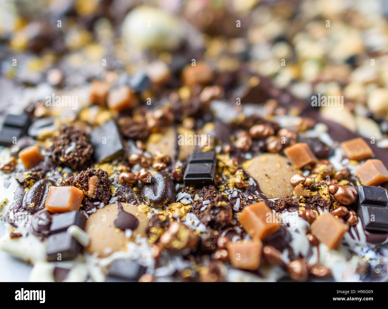 Un glittery lastra di cioccolato fuso, fudge e chicchi di caffè da vicino il fuoco selettivo. Foto Stock