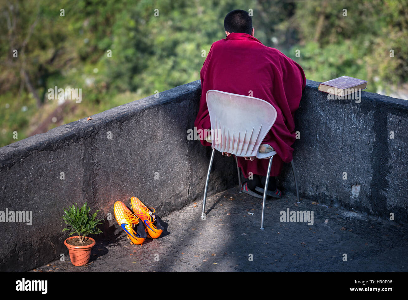 Un giovane monaco in appoggio, McLeod Ganj Dharamsala, Himachal Pradesh, India Foto Stock