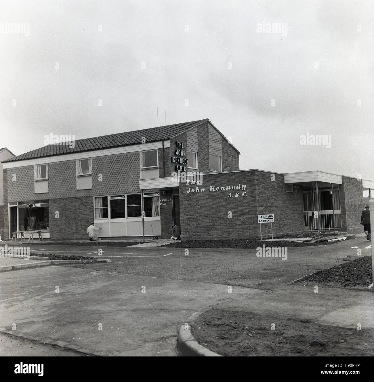 1965 storico, immagine mostra i lavoratori ultimando la nuova costruzione public house, John Kennedy A. B.C, chiamato dopo il trentacinquesimo presidente americano, in Meadowcroft, Aylesbury, Inghilterra. Foto Stock
