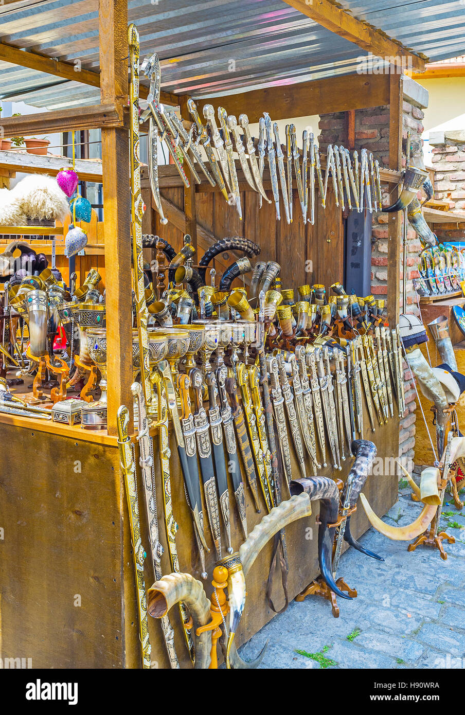 Il tradizionale georgiano arma a freddo - acciaio pugnale nella riccamente decorate guaina - goffrato, inseguiti, modelli di filigrana e intarsi in pietra, mercato Mtskheta Foto Stock