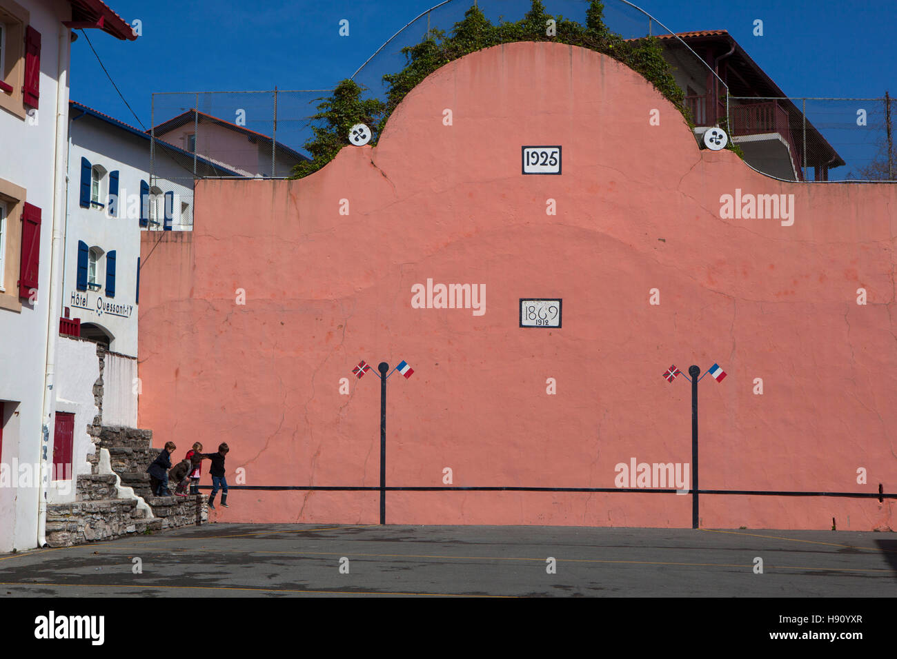 I bambini che salta da un muro nella pelota tribunale della città di Bidart, Biarrtiz, Paese Basco, Francia Foto Stock