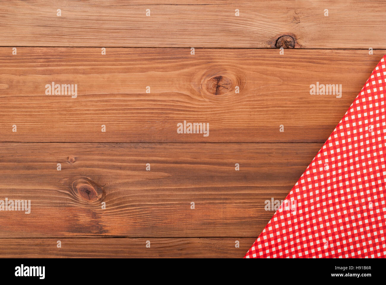 Rosso a scacchi stoffa su un tavolo di legno. Foto Stock