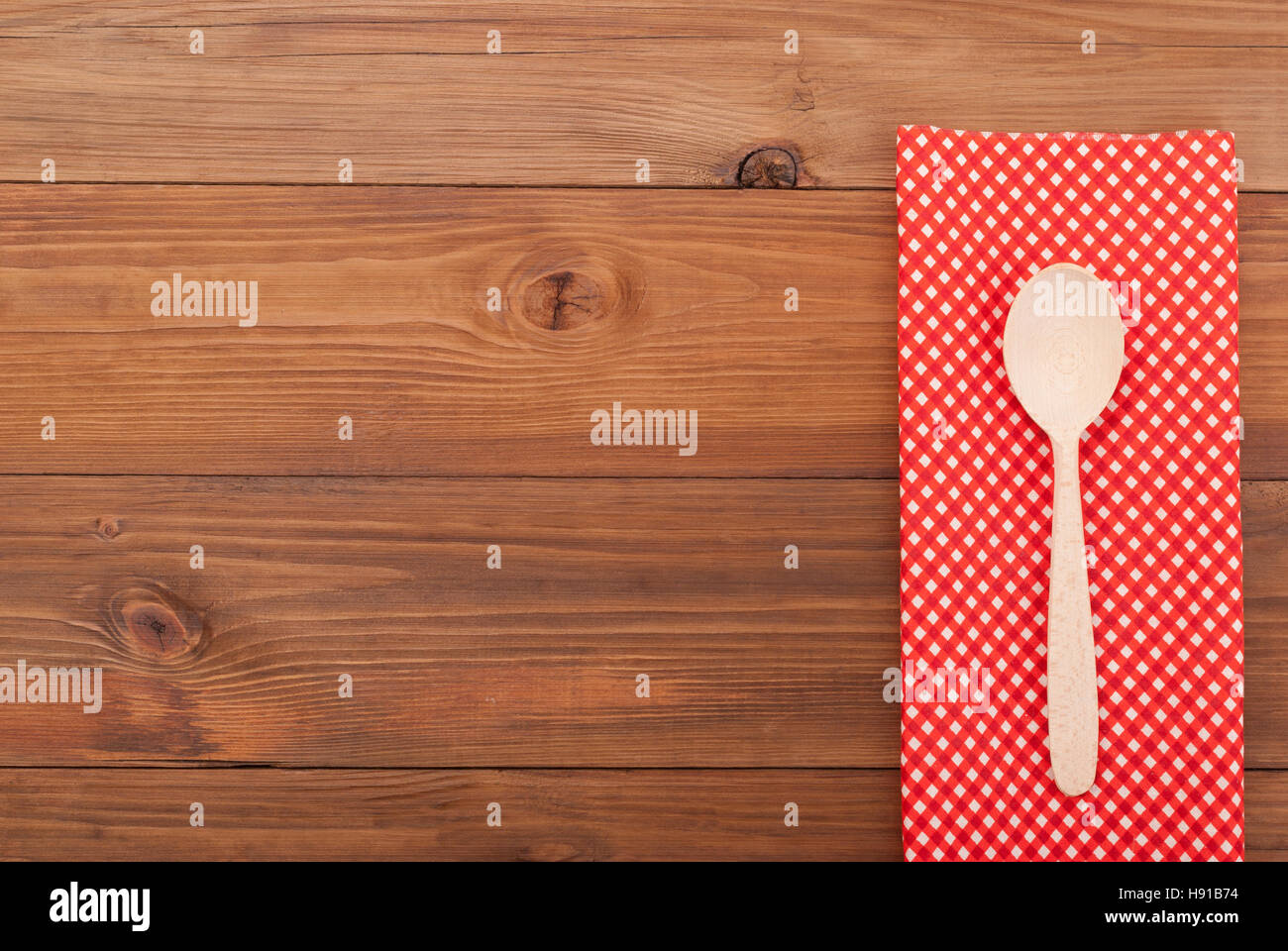 Cucchiaio e tovagliolo su sfondo di legno. Foto Stock