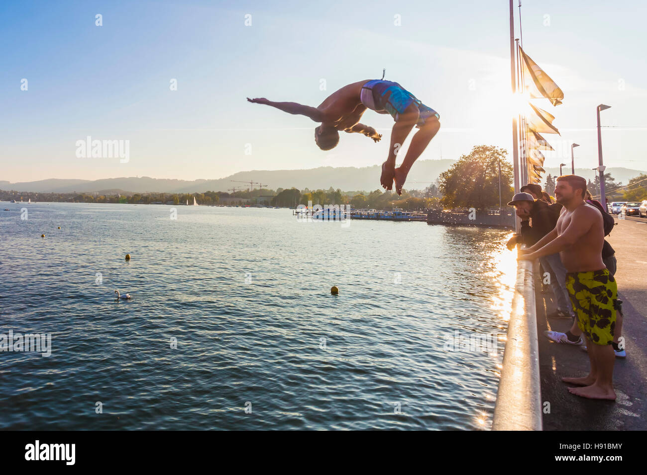 Giovane uomo Salto dal ponte QUAIBRUCKE nel lago di Zurigo, Zurigo, Svizzera Foto Stock
