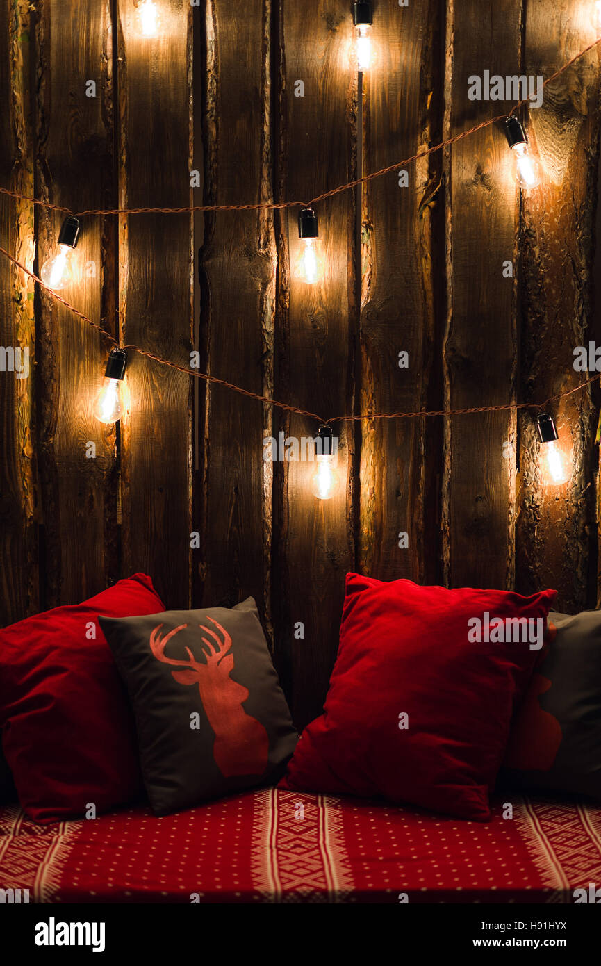 Testa di cervo su rosso fatto a mano cuscino sfondo di legno in interni Foto Stock