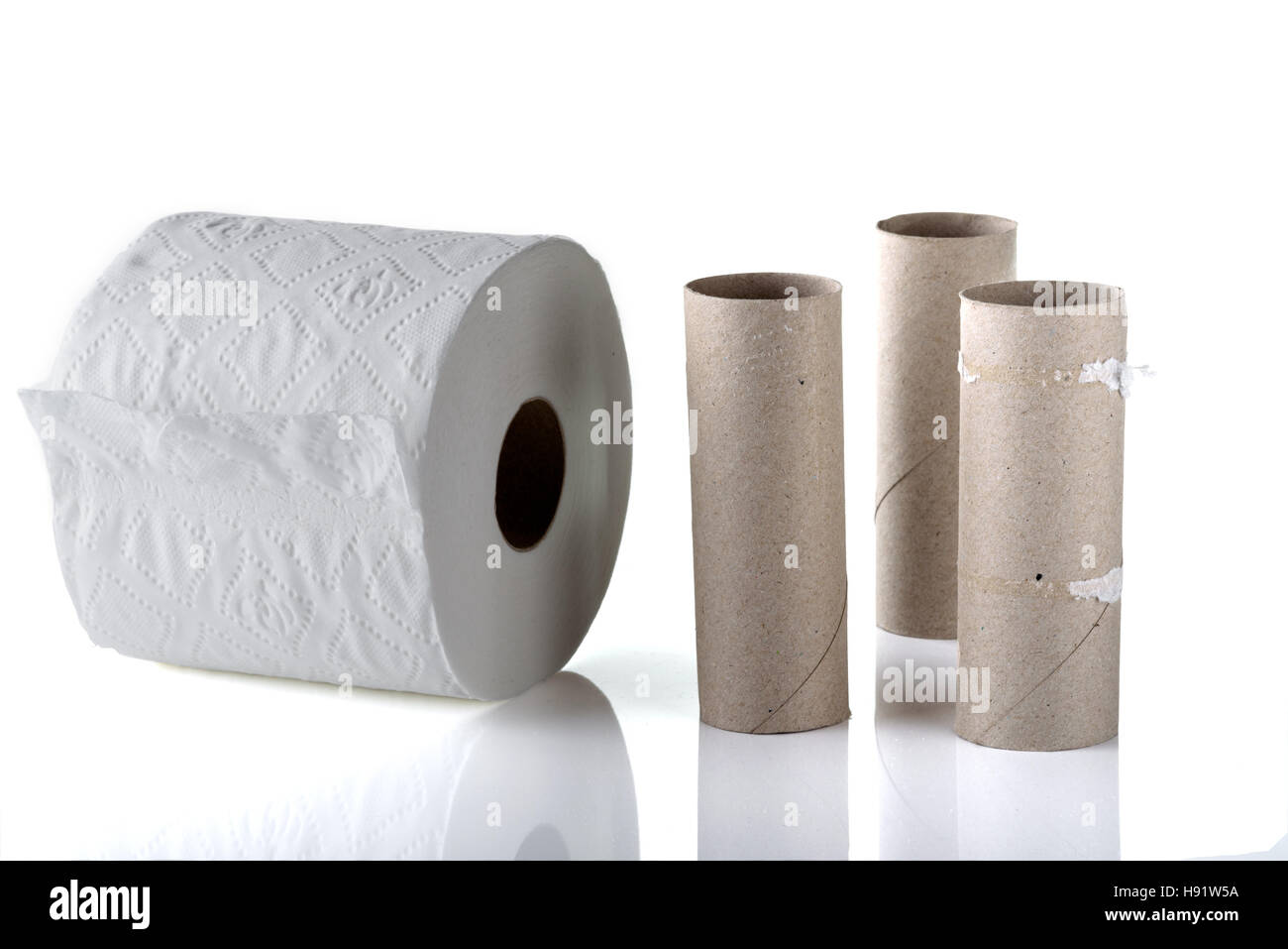 Vuoto tre rotoli di carta igienica al fianco di un nuovo rullo pieno. Foto Stock