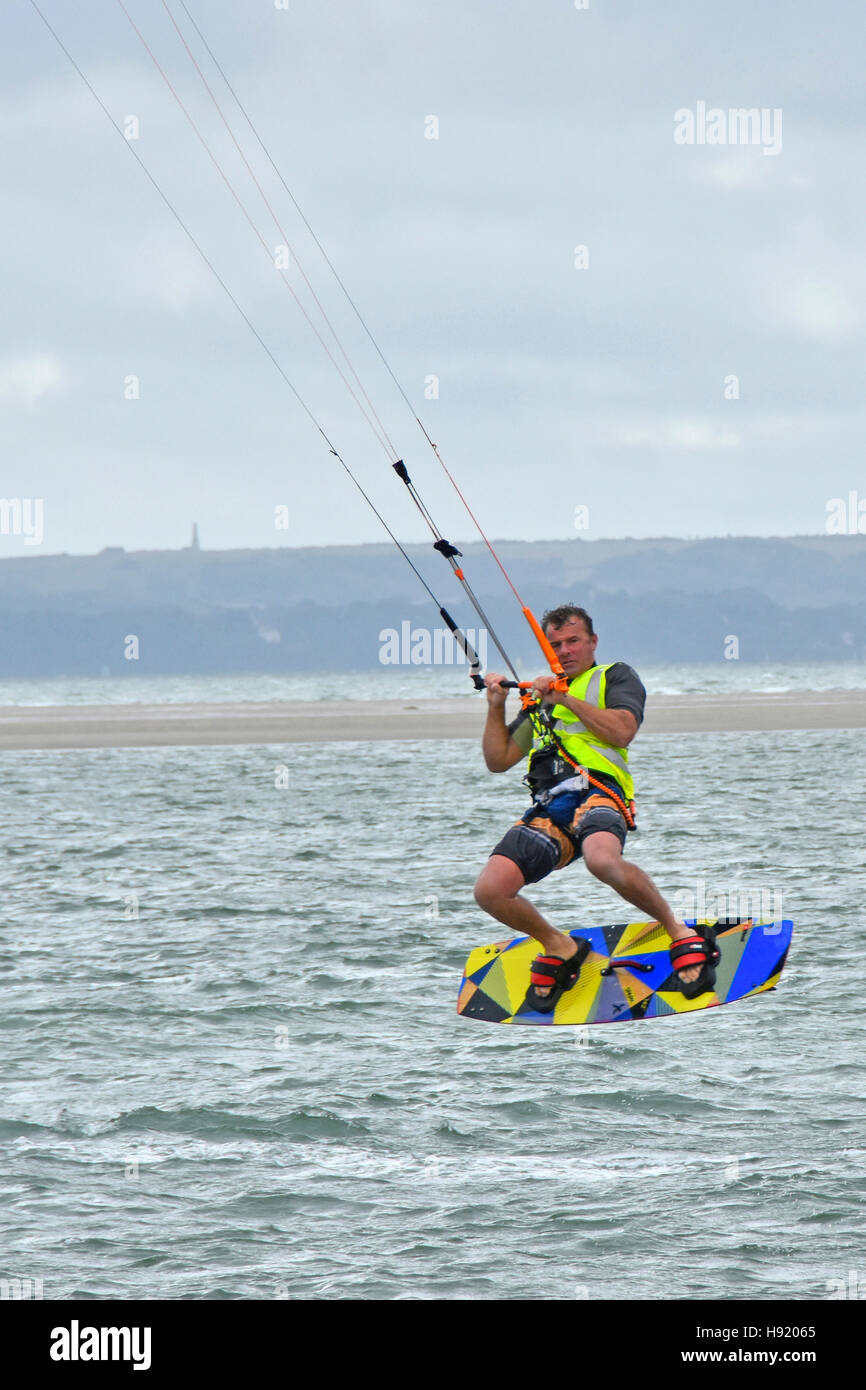 Uomo di azione kite surf board salto acrobatico trucco al largo della costa di Hayling Island Hampshire REGNO UNITO Inghilterra popolare acqua kitesurf sport stunt  Foto Stock