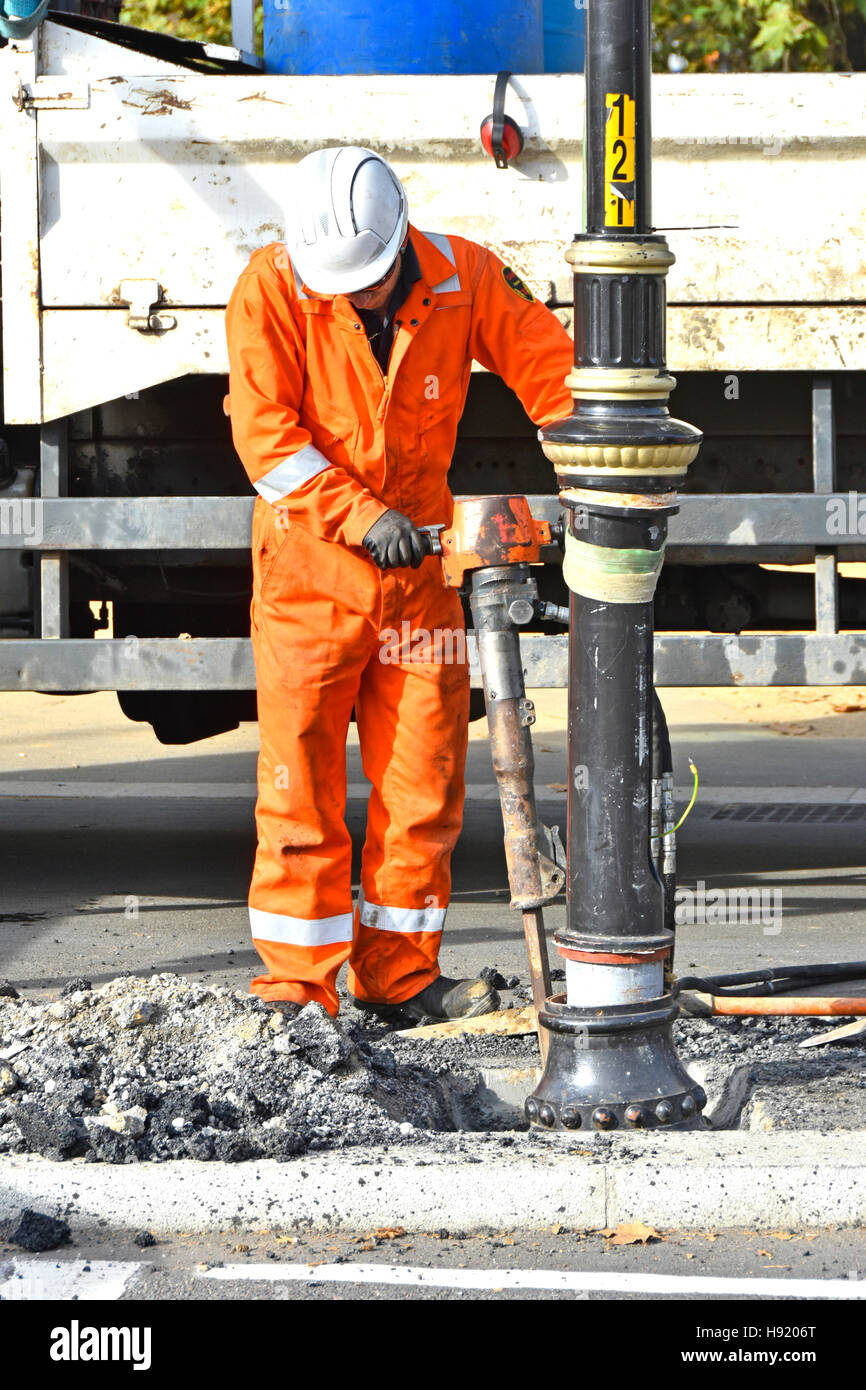 Lavoro di riparazione su strada con martello pneumatico Attrezzatura utensile che si rompe intorno lampione di strada Londra Inghilterra REGNO UNITO Foto Stock