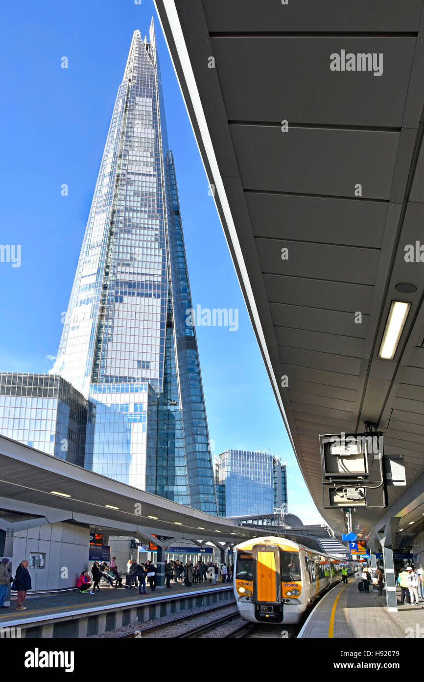 Shard simbolo di Londra Regno Unito la costruzione di grattacieli torreggianti sull'infrastruttura del rinnovato la stazione di London Bridge binario ferroviario piattaforme e treno Foto Stock
