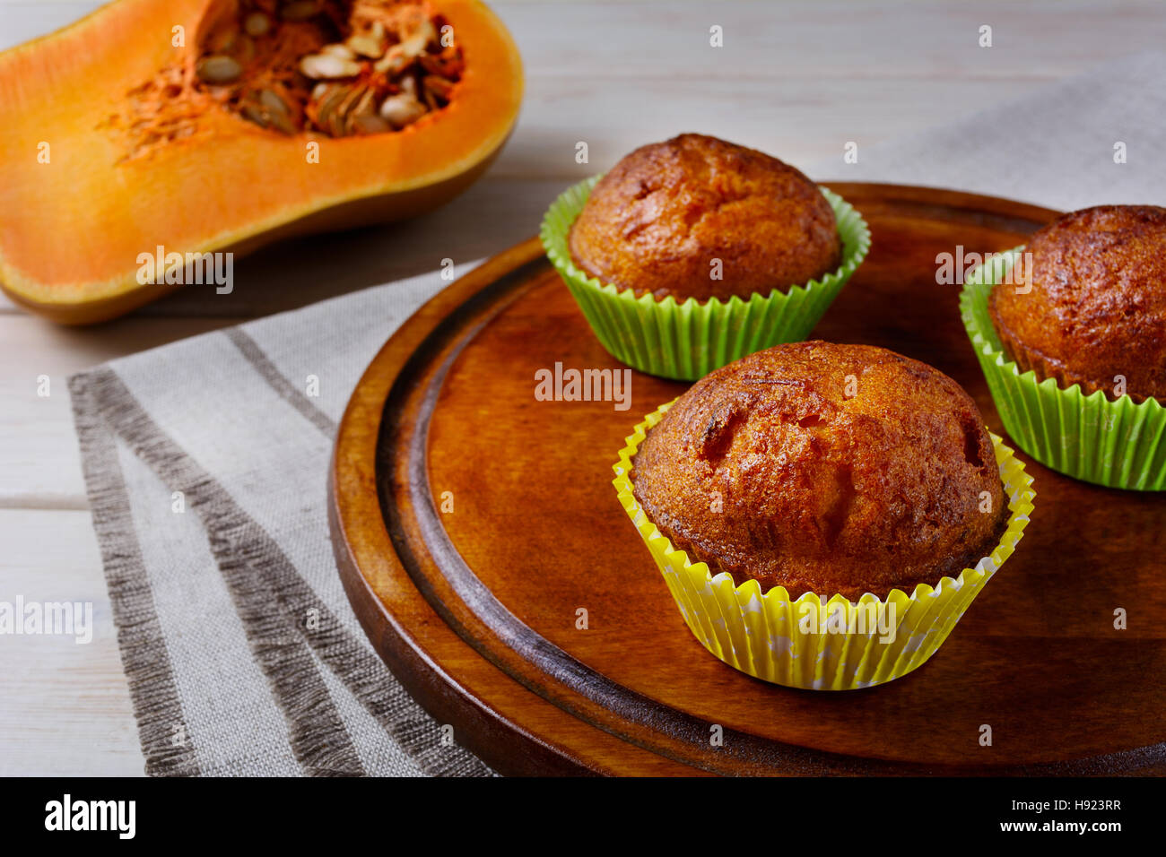Fatti in casa muffin di zucca sul tagliere e zucca. Caduta stagionale cibo vegetale. Ringraziamento dolci fatti in casa la pasticceria. Foto Stock