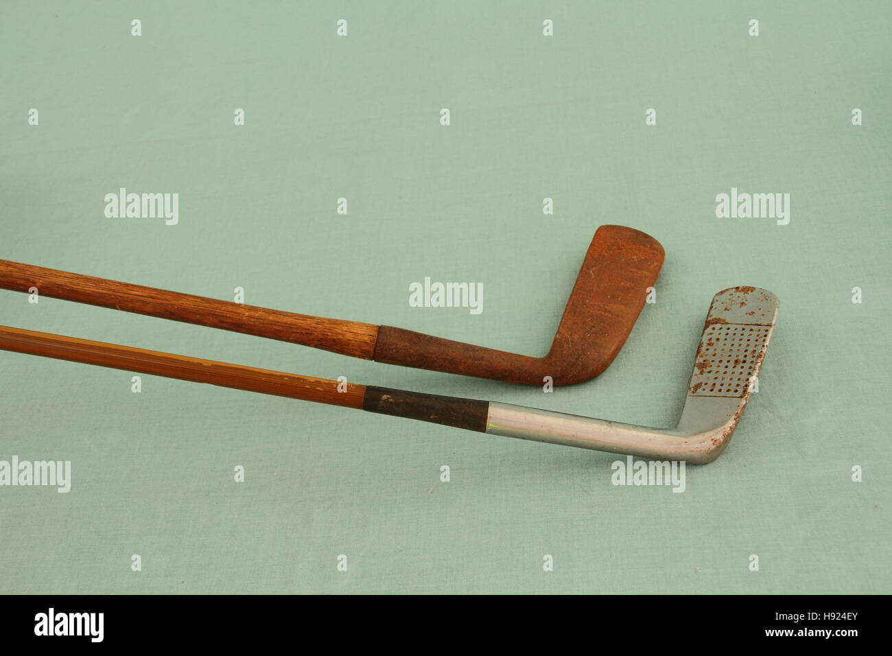 Due hickory scopare golf club isolato su un verde chiaro immagine di sfondo con spazio di copia Foto Stock