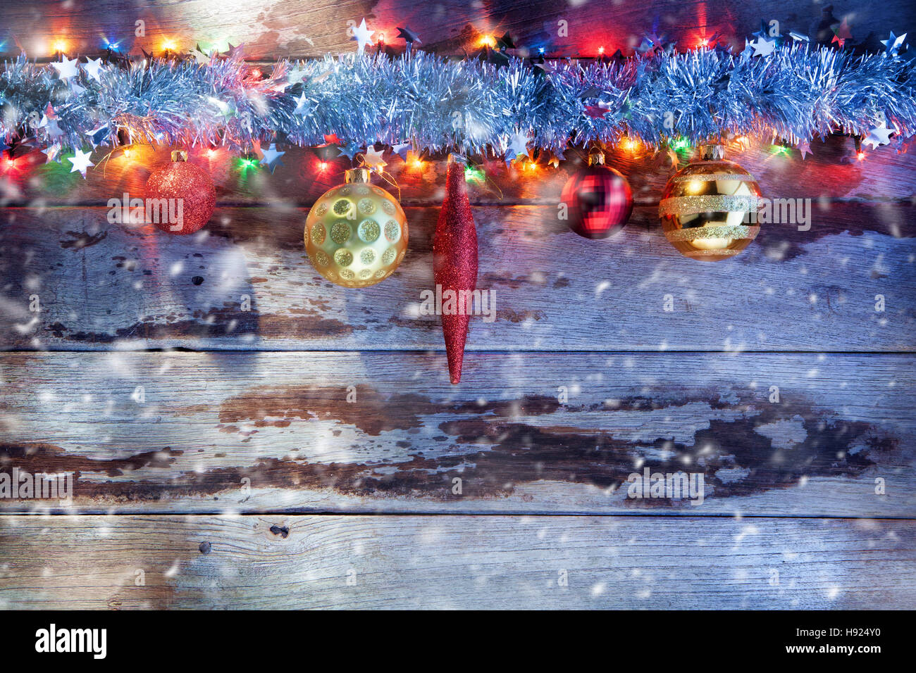 Vista ravvicinata di albero di natale giocattoli e luci con dorso in legno Foto Stock