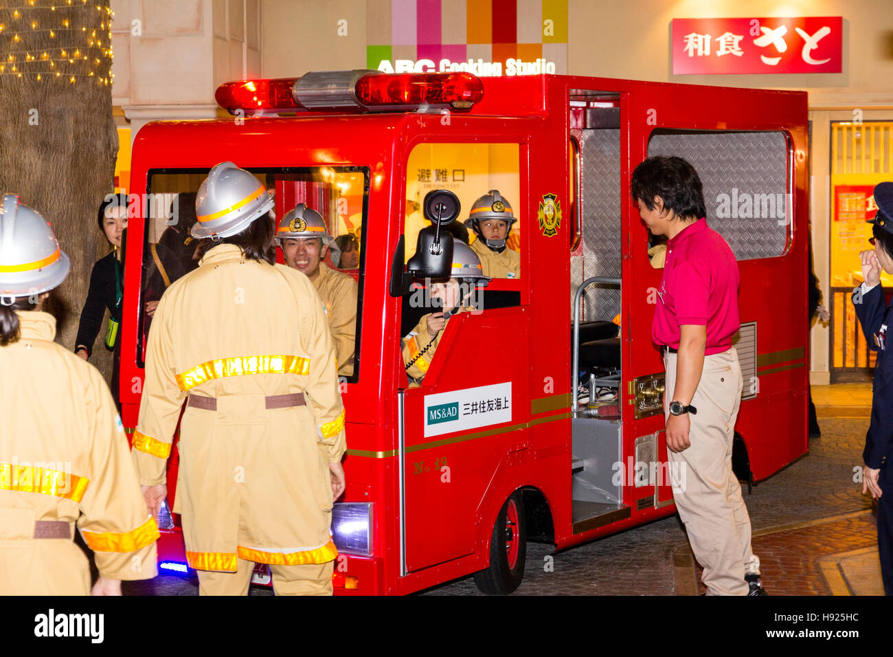 Giappone, Nishinomiya, KidZania, attività figlio il centro del gioco. Interno. I bambini la guida motore fire attraverso mock up street. La notte. Foto Stock