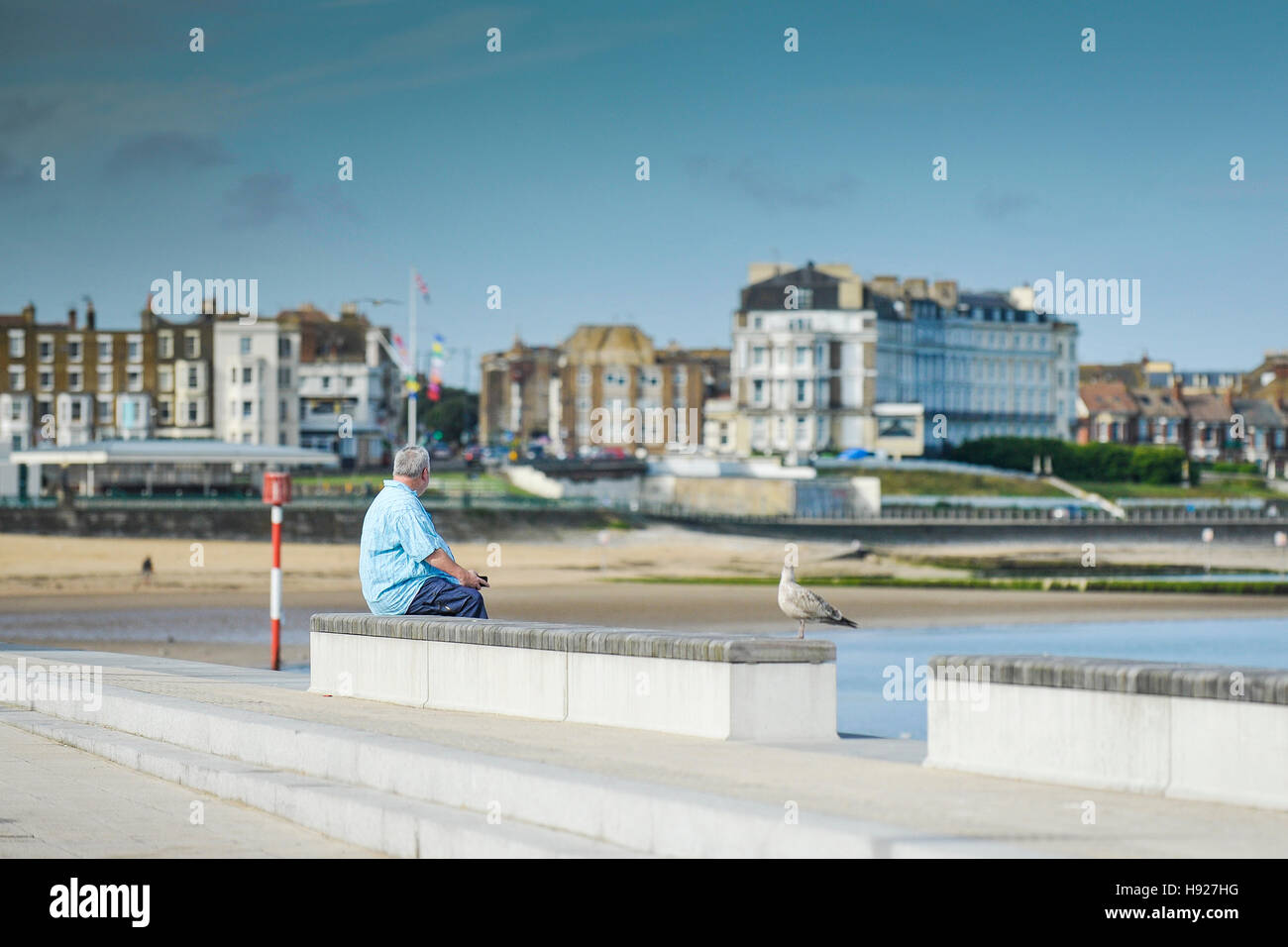 Un uomo si siede sul lungomare a Margate nel Kent. Foto Stock