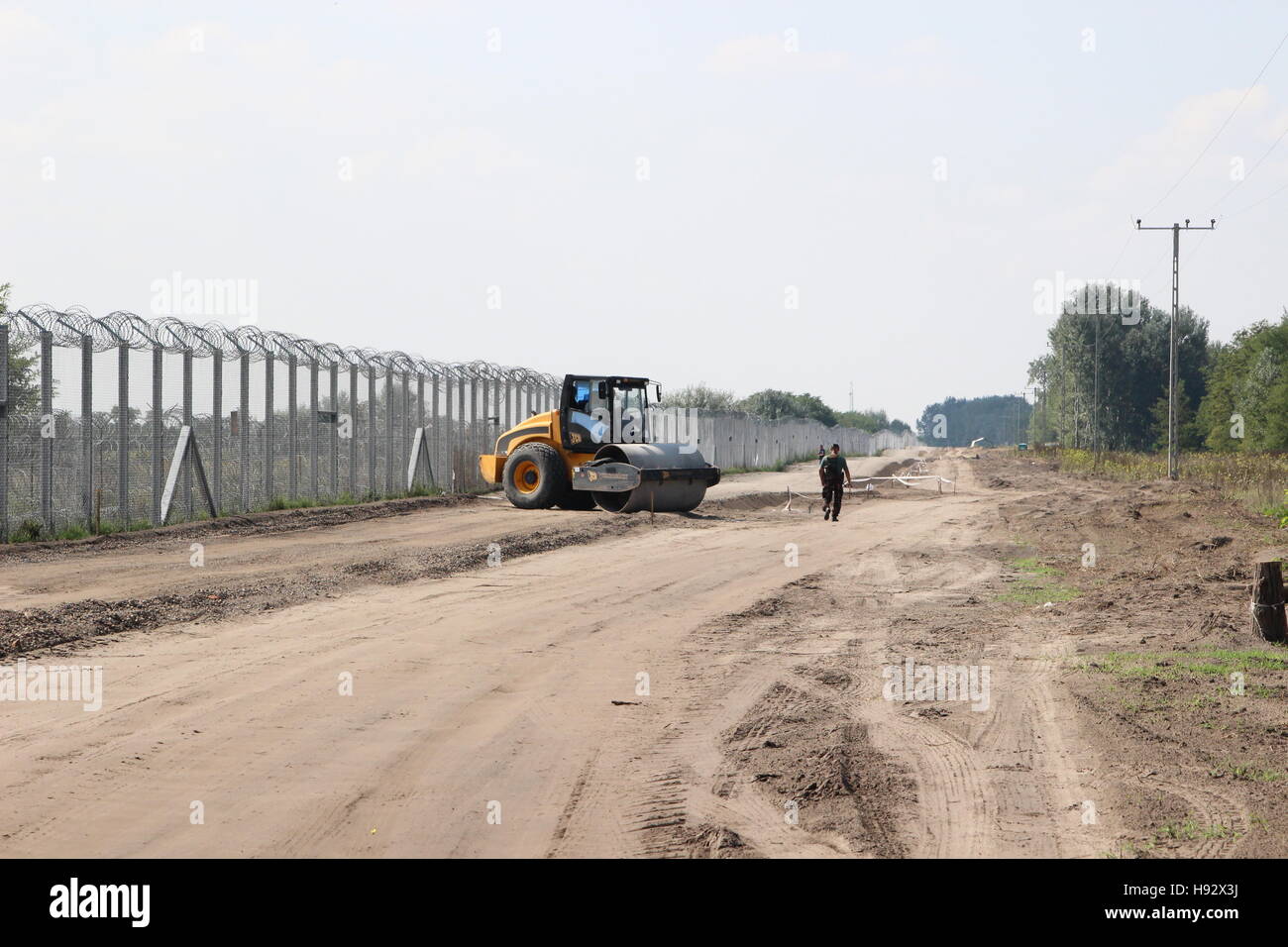 Il militare ungherese costruisce una vera e propria strada vicino al recinto sulla frontiera meridionale del paese. Foto Stock