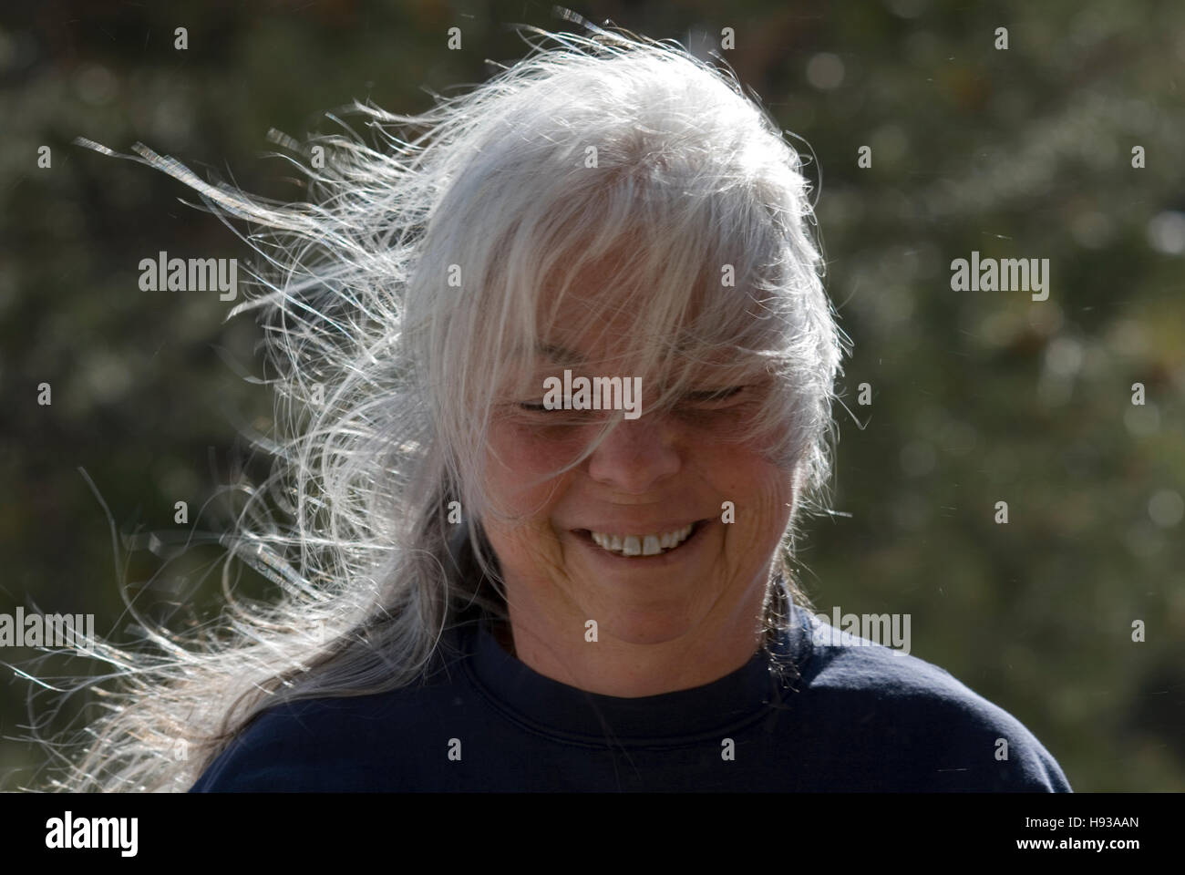 Carino foto di donna matura con i suoi capelli grigi al vento. Foto Stock