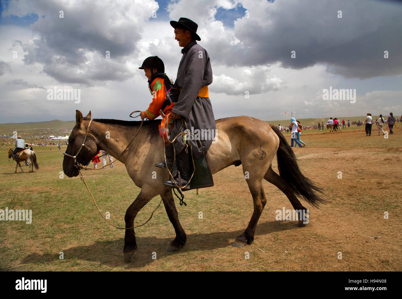 Dopo la corsa di cavalli, il concorrente kid condivide la sua gioia con il padre nella città di Ulan Bator, Mongolia. Foto Stock