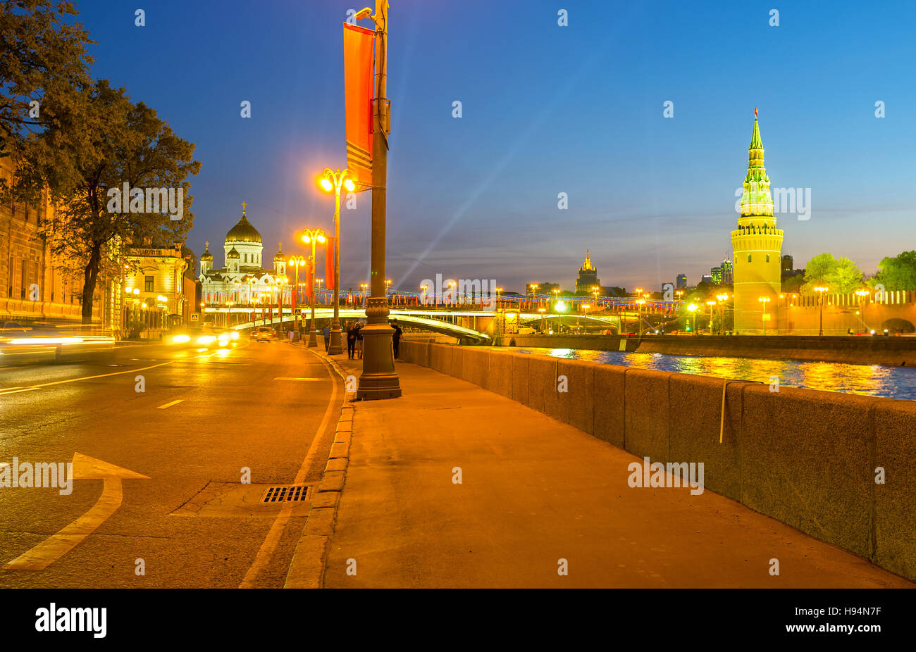 La passeggiata serale lungo il fiume Moskva a Sofiyskaya embankment con la vista sulla Torre Vodovzvodnaya del Cremlino e la Cattedrale di Cristo Salvatore, Foto Stock