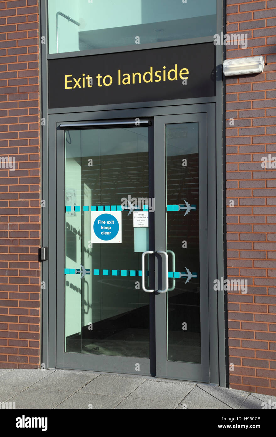 Il personale uscire dall'Airside per aree Landside presso l'aeroporto di Gatwick, Regno Unito. Grande 'Uscita a Landside' segno sopra porta. Foto Stock