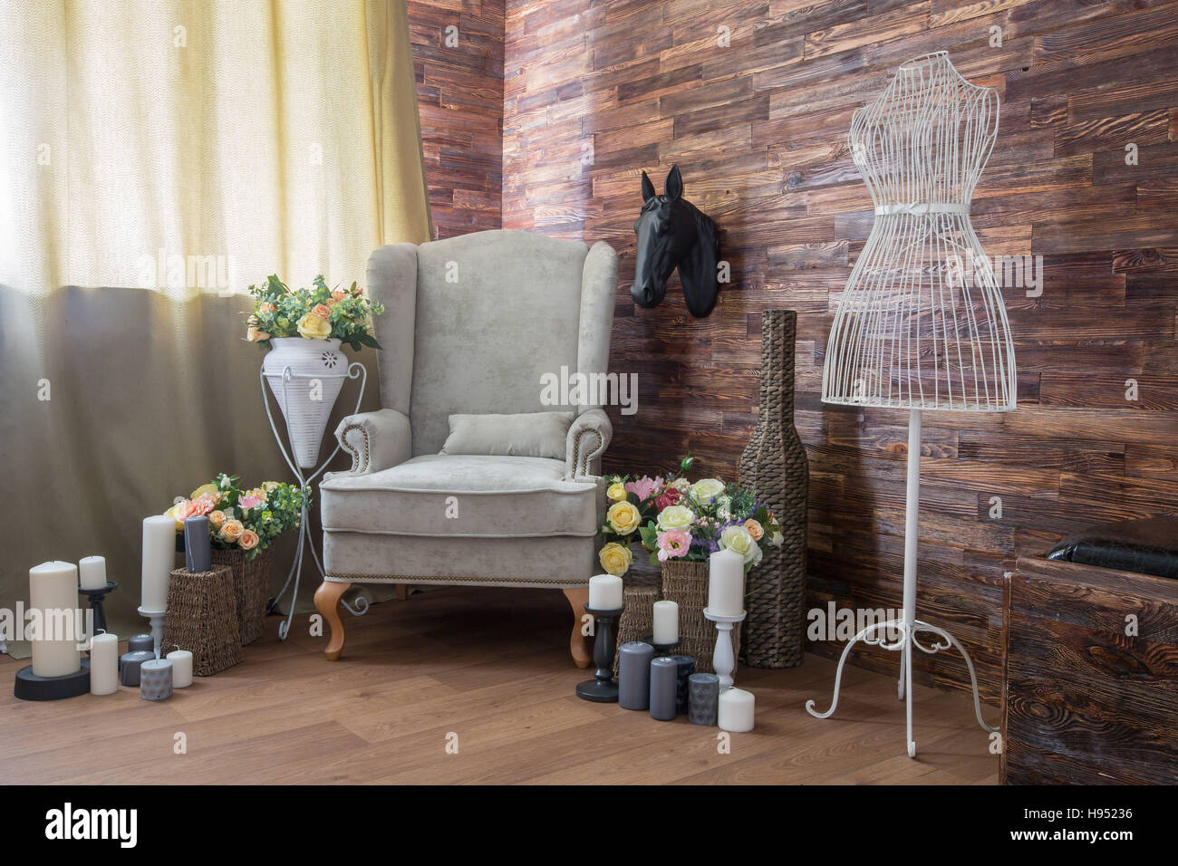 Design accogliente camera con una sedia, candele e fiori Foto Stock