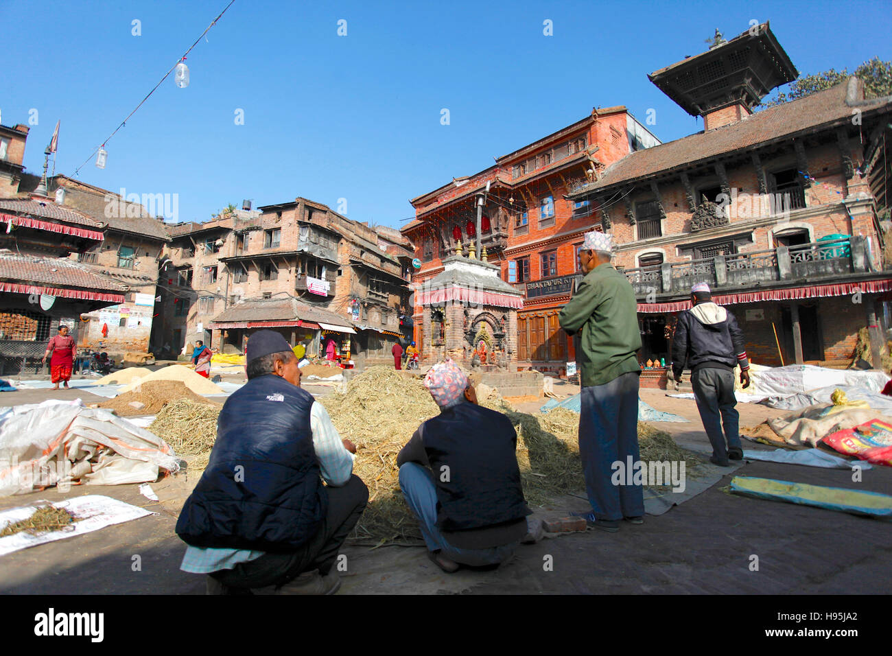Gli uomini di chattering in ceramica quadrata. Bhaktapur, Nepal. Foto Stock