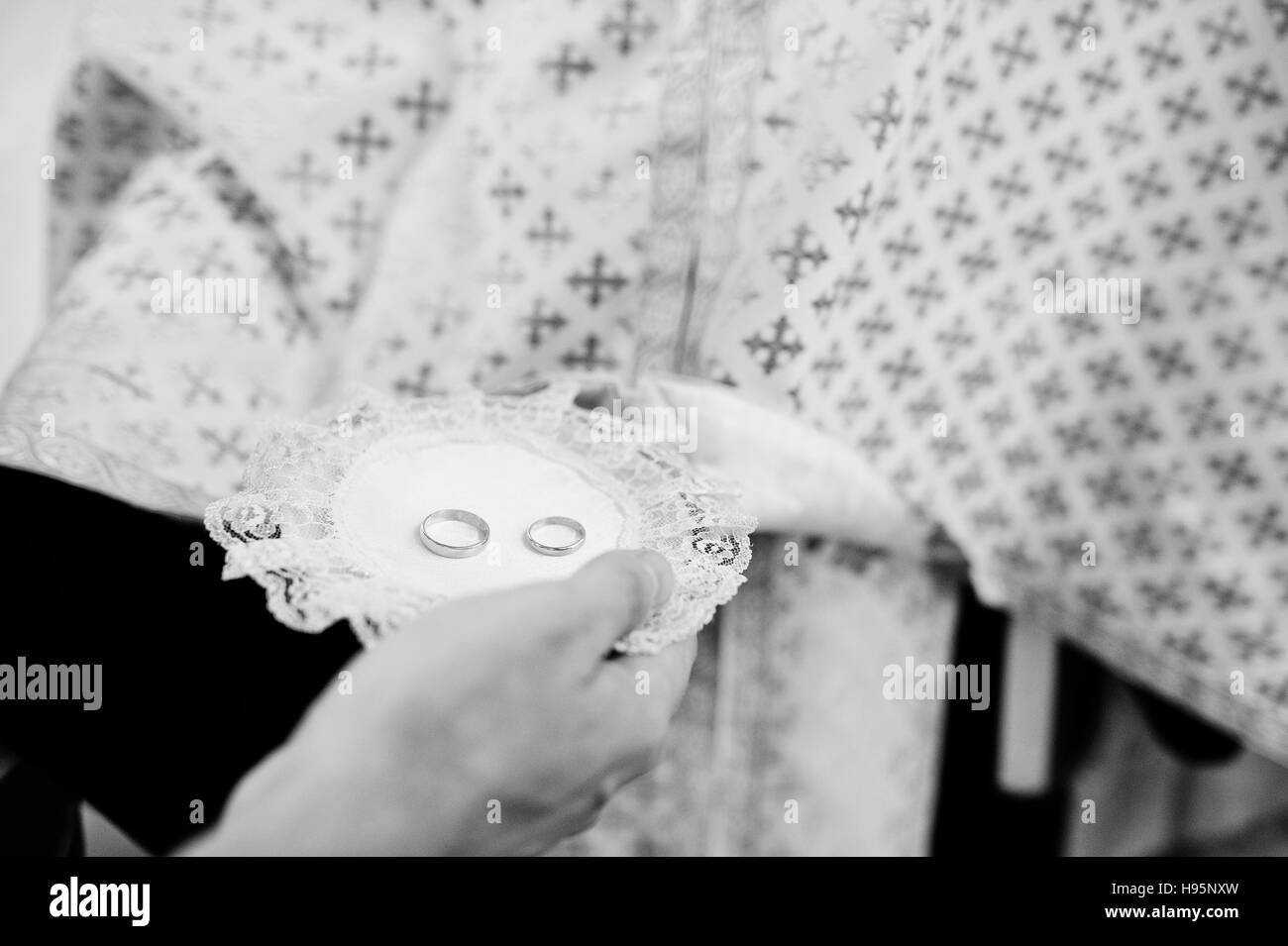 Gli anelli di nozze su piastra in chiesa cerimonia. Foto in bianco e nero Foto Stock