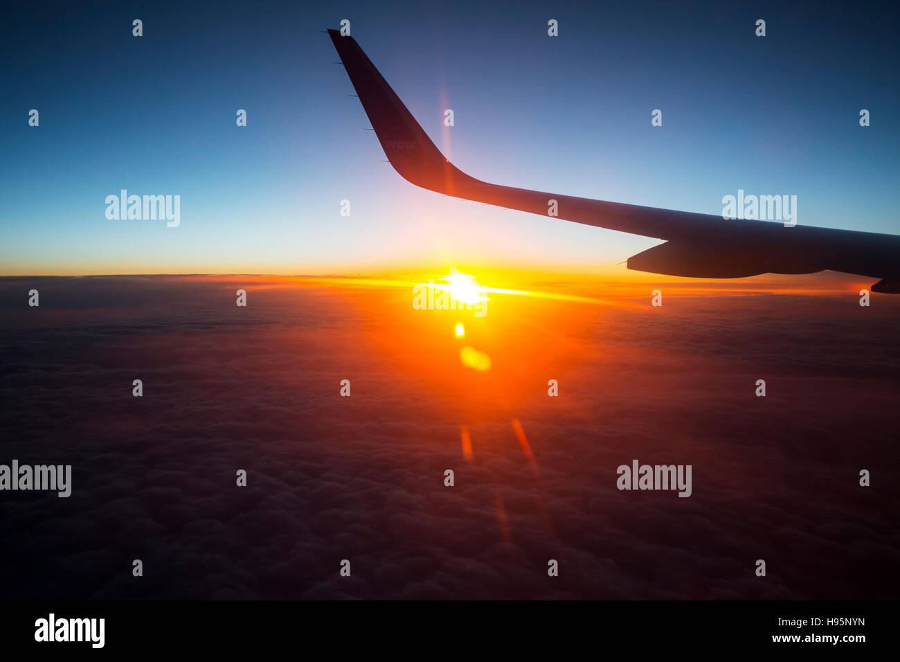 Aereo volare verso il sole di mezzanotte in rotta per l'Islanda Foto Stock