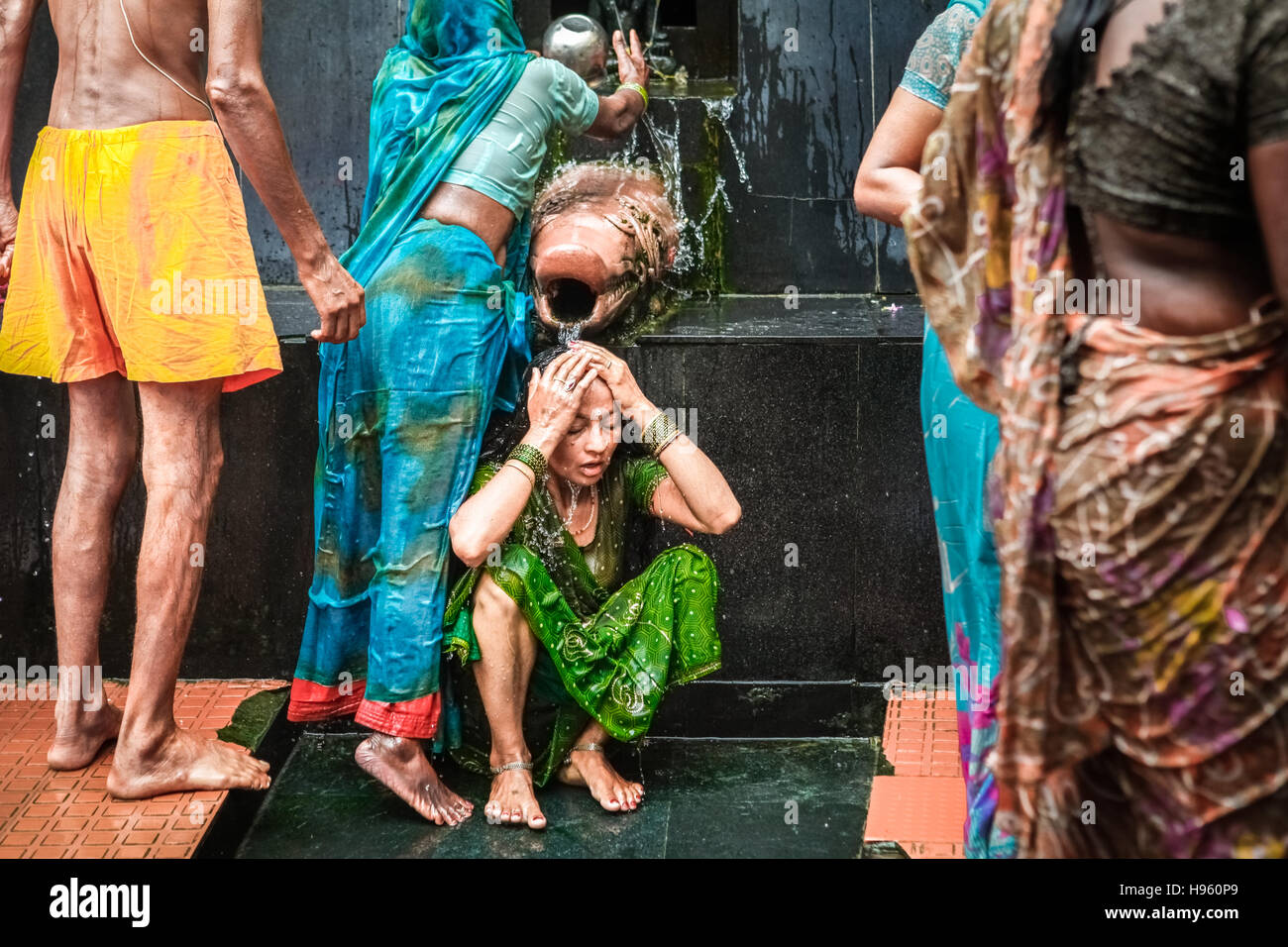 Una donna pilgim che prende un bagno in acqua Santa da una sorgente calda al complesso di tempio di Lakshmi Narayan in Rajgir, Bihar, India. Foto Stock