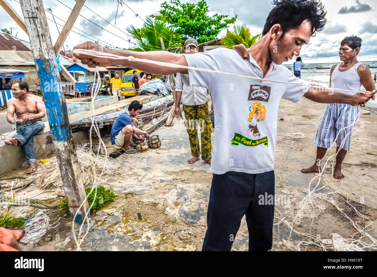 Pescatori che riparano le linee di pesca sulla spiaggia del villaggio di Malabro a Bengkulu, una città di Sumatra costa occidentale di fronte all'Oceano Indiano. Immagine di archivio. Foto Stock