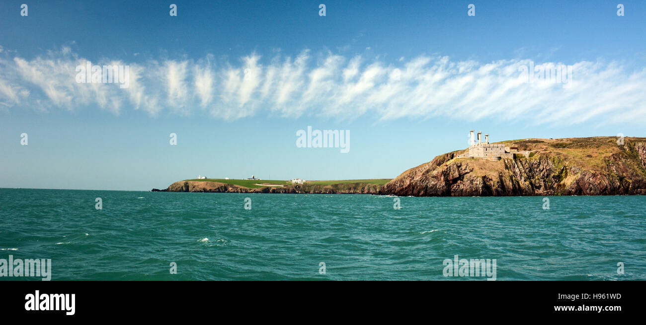 Fascia di tempo equo cirrus nuvole sopra st Ann la testa e il faro in distanza fuori dale in pembrokeshire Foto Stock