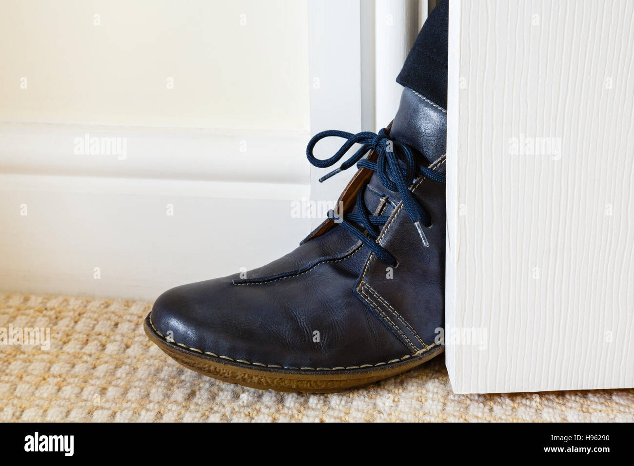 Una persona non gradita che ottiene un piede nel gioco della porta aperta all'interno di una casa. Concetto di molestie. Inghilterra, Regno Unito, Gran Bretagna Foto Stock