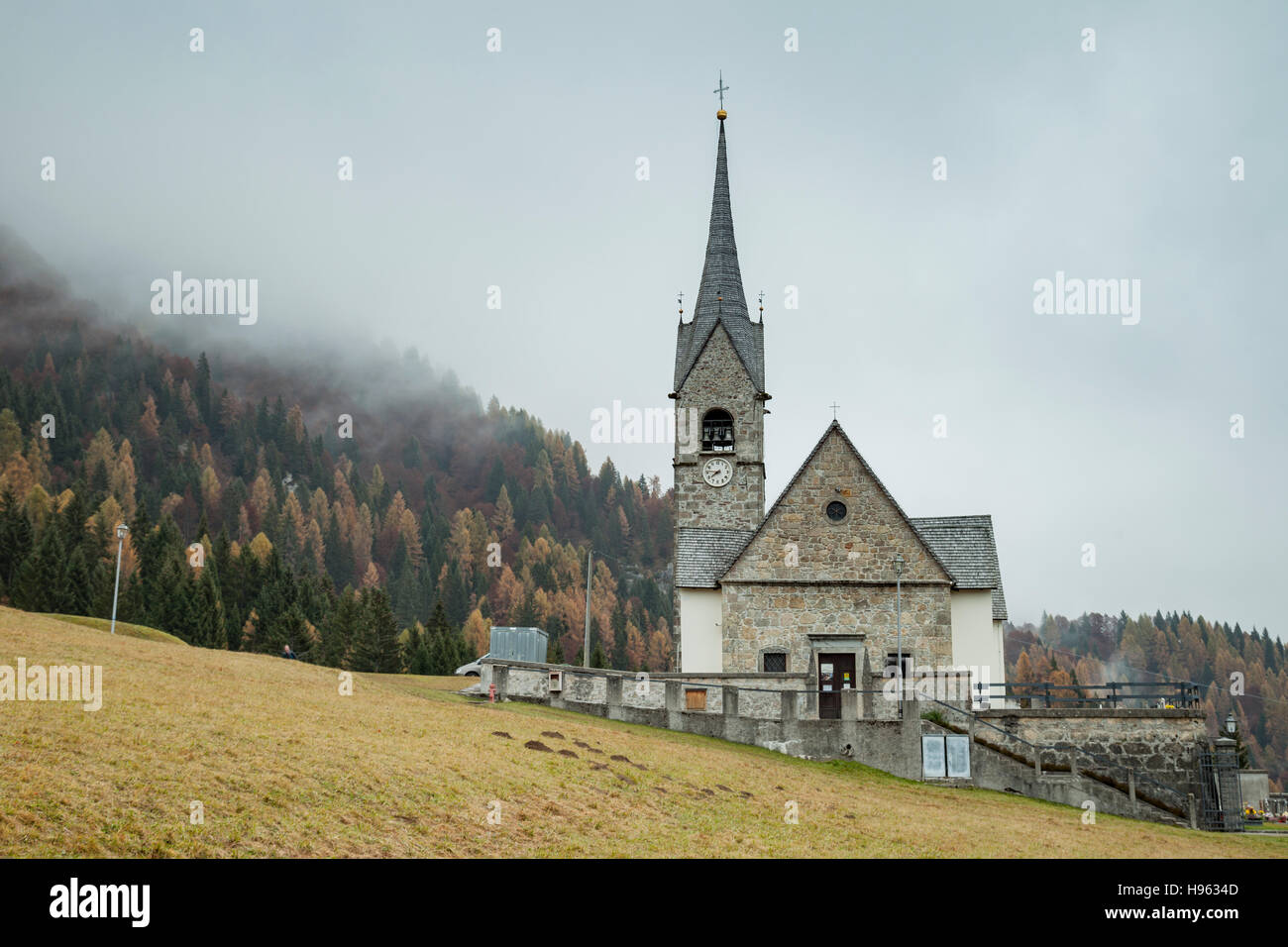 Nebbiose giornate d'autunno all'iconico chiesa di San Lorenzo a Sauris di Sopra, provincia di Udine, Italia. Dolomiti. Foto Stock