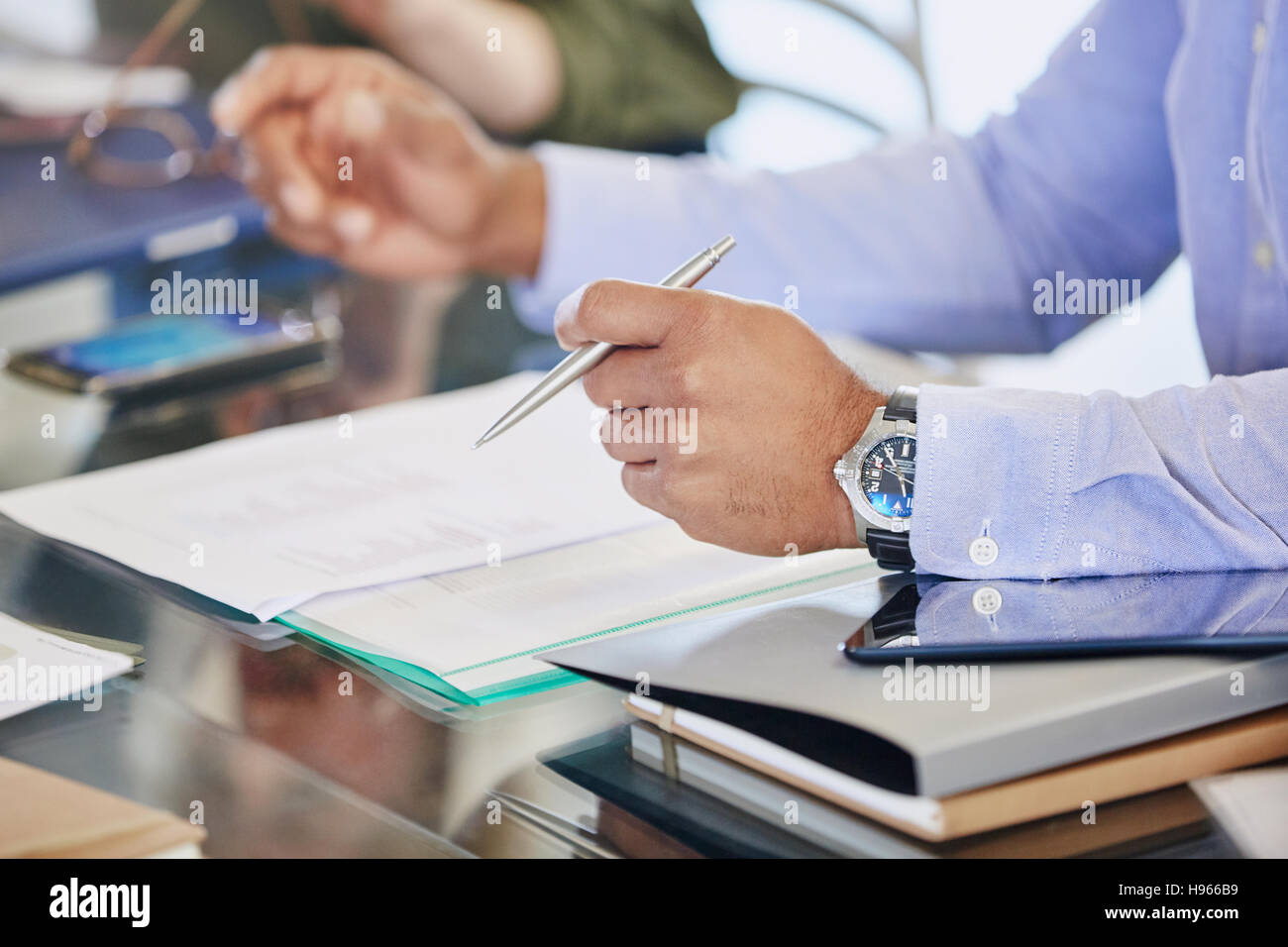 Imprenditore tenendo la penna sulla documentazione in riunione Foto Stock