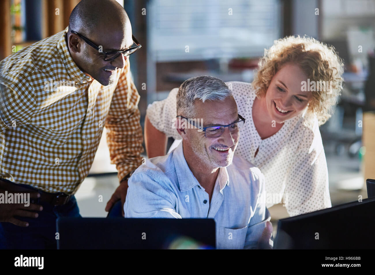 Sorridente business persone che lavorano al computer in ufficio Foto Stock