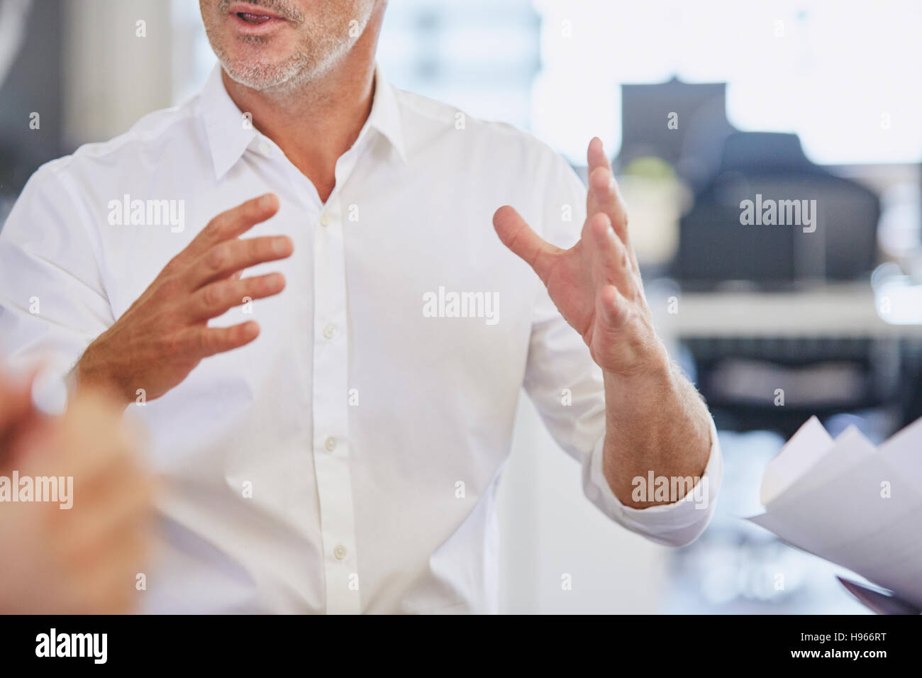 Imprenditore gesticolando in riunione Foto Stock