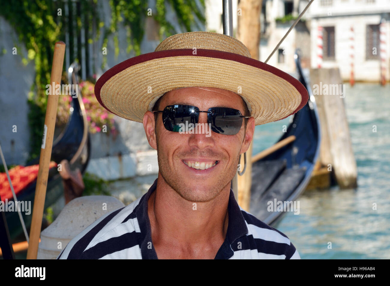 Gondoliere con il tipico copricapo su un canale di Venezia in Italia. Foto Stock