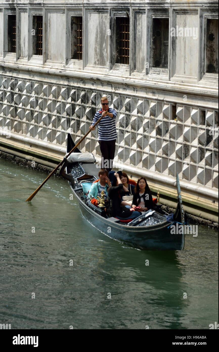 Gondola con turisti e gondoliere su un canale di Venezia. Foto Stock