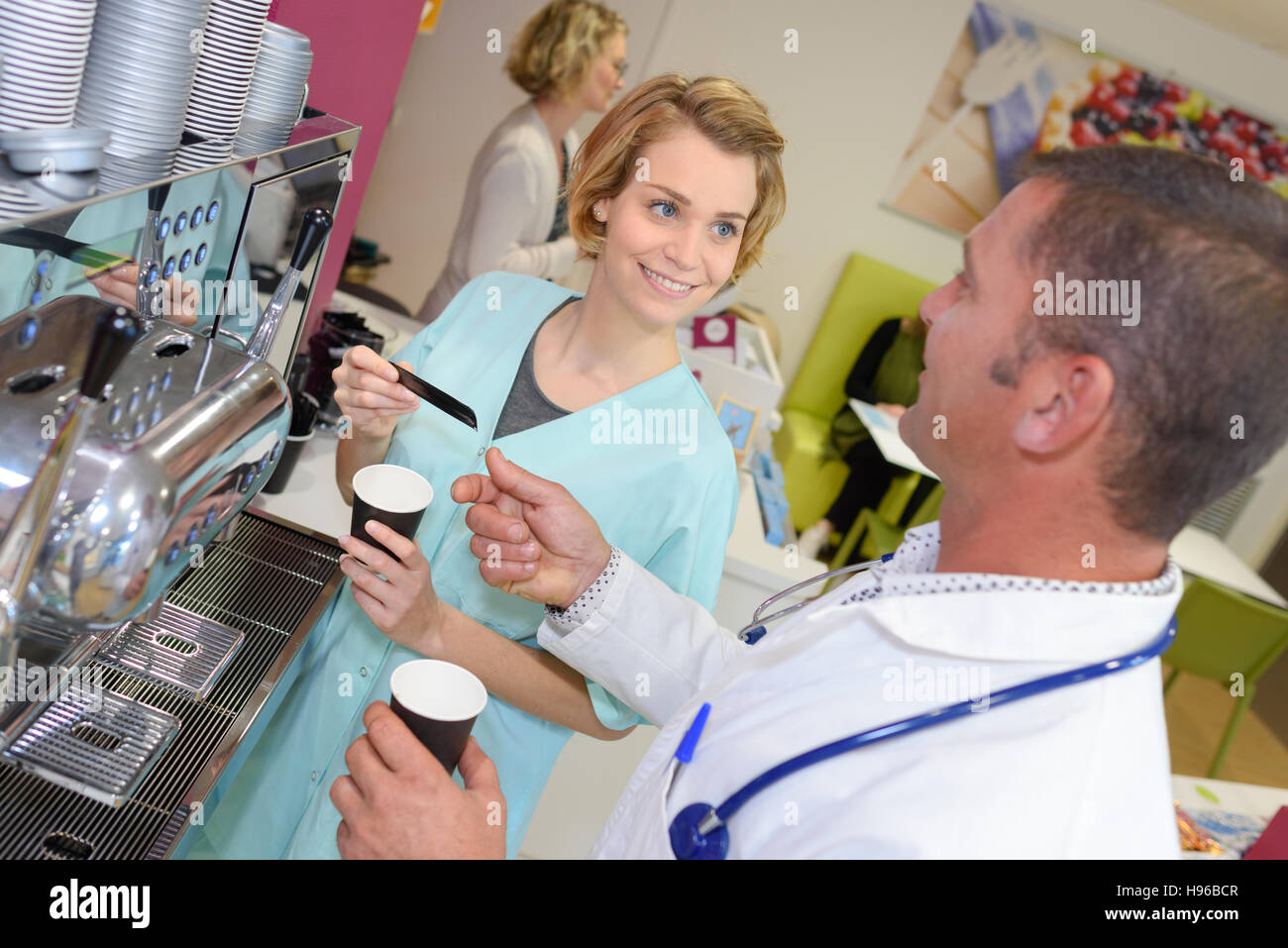 Il personale medico a chattare in un moderno ospedale mensa Foto Stock