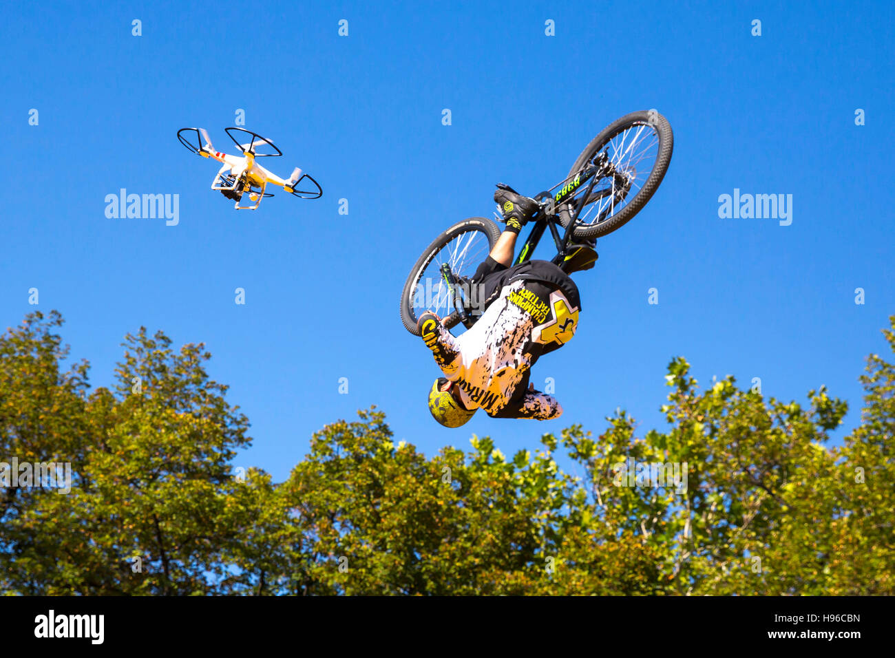 Sofia, Bulgaria - 24 Settembre 2016: ciclista salta contro il cielo blu e alberi corredata di un flying drone. Foto Stock