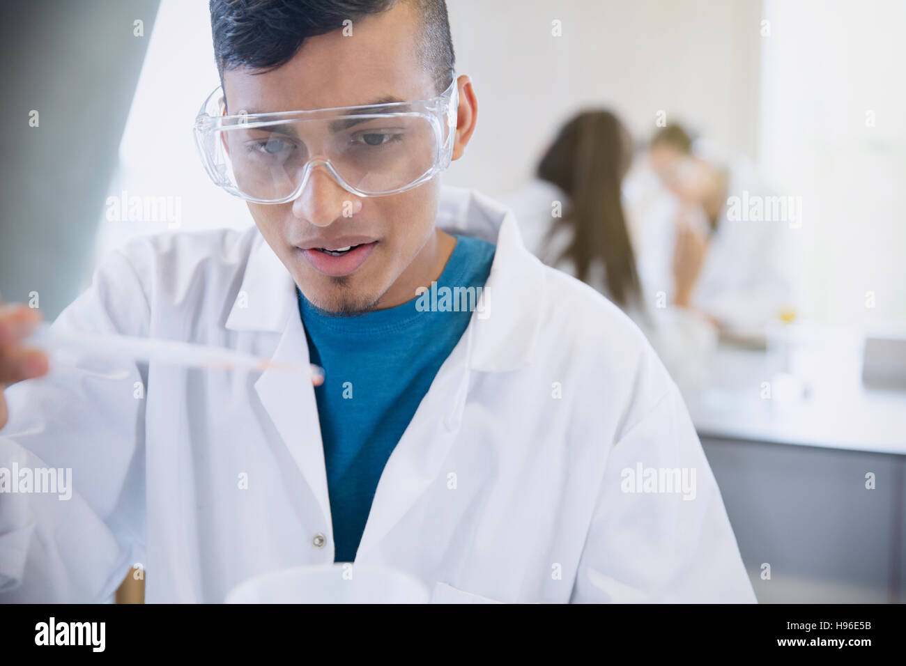 Collegio maschile studente condurre esperimenti scientifici in Science Laboratory classroom Foto Stock