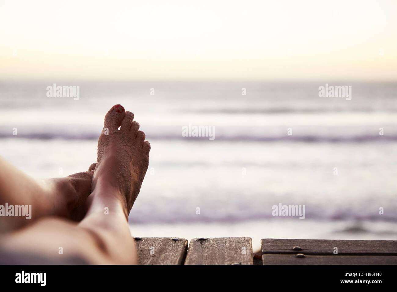 Punto di vista personale a piedi nudi donna con sabbia a piedi e vista oceano Foto Stock