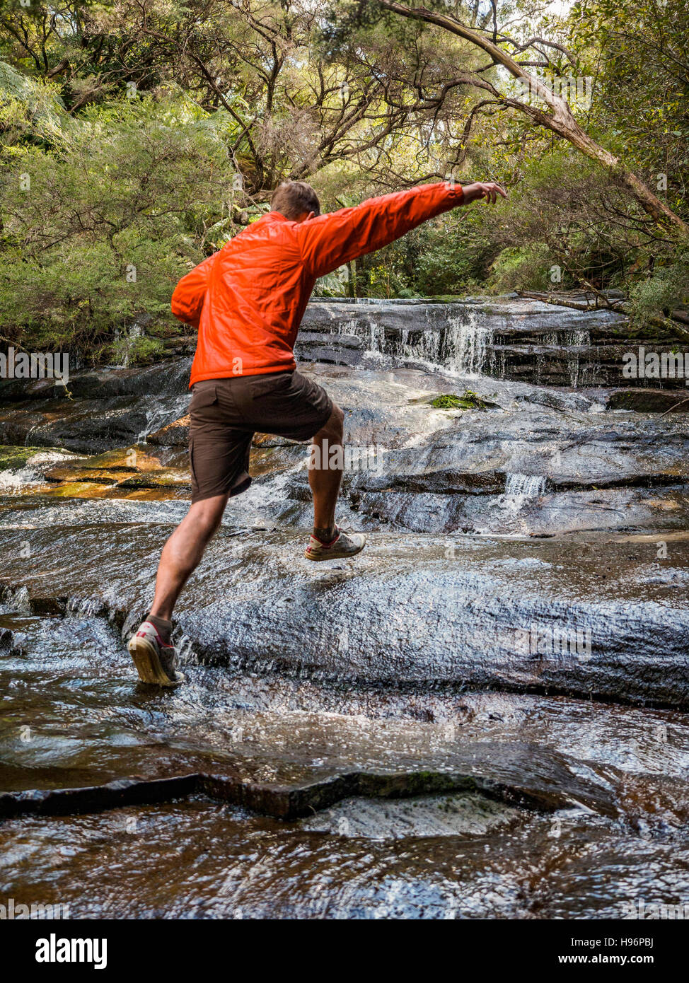 Australia, Nuovo Galles del Sud, Katoomba, uomo in esecuzione su rocce di Leura cascata Foto Stock