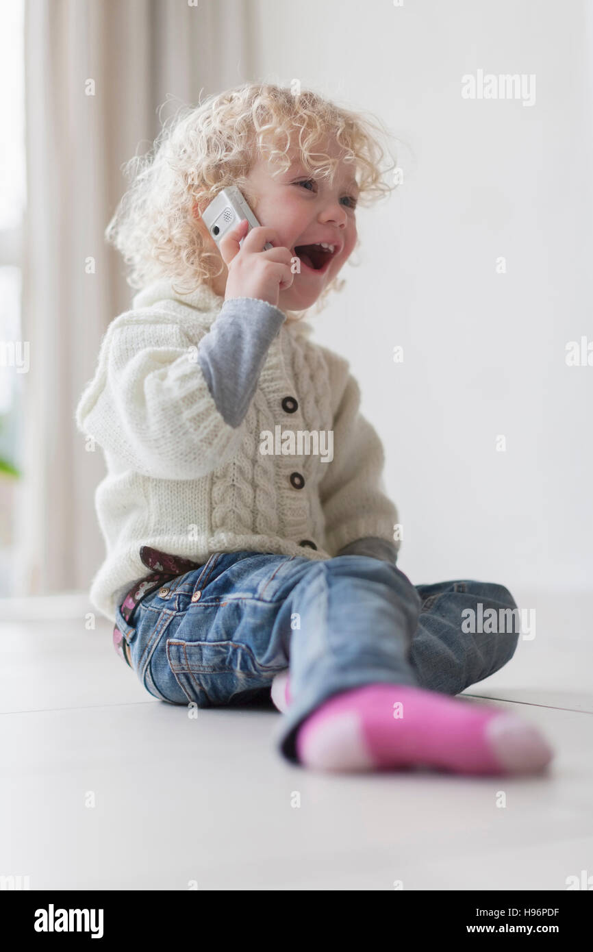 Ragazza bionda (4-5) giocando con il telefono cellulare Foto Stock