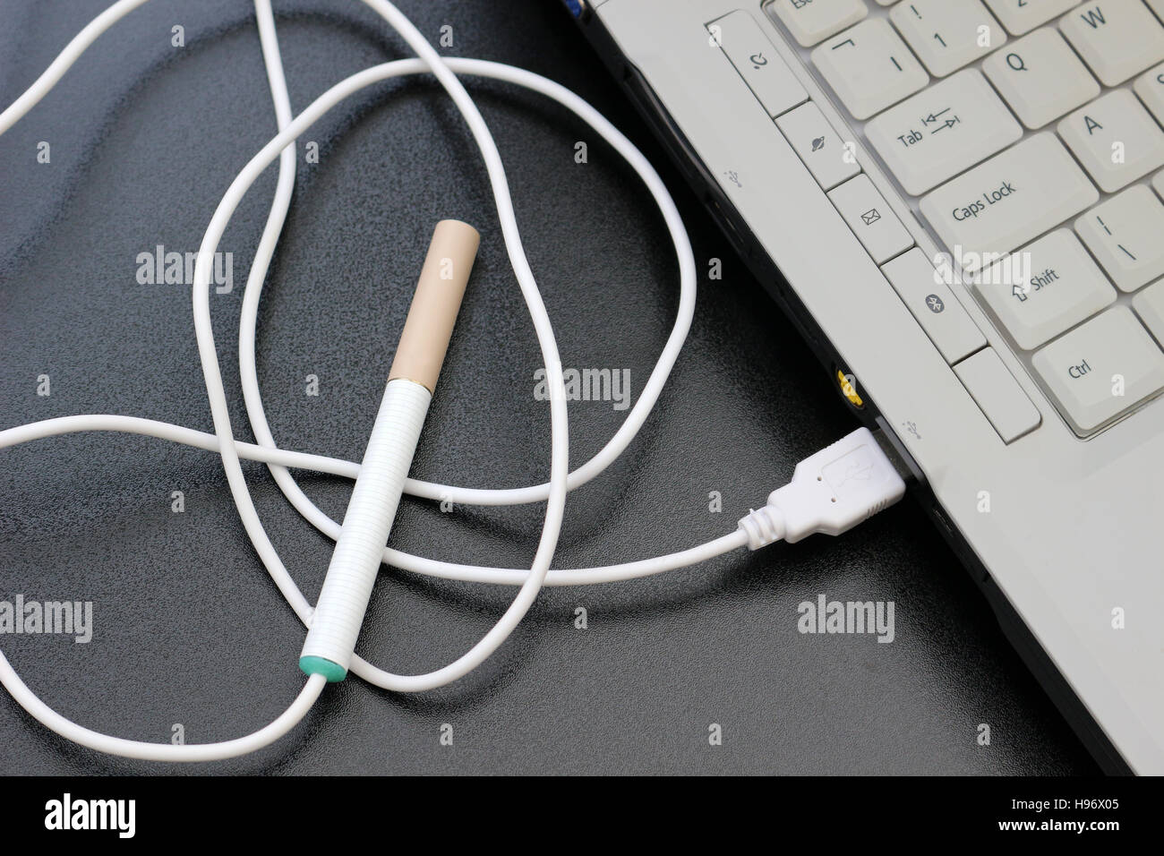 sigaretta elettronica collegata a una porta usb di un computer portatile Foto Stock