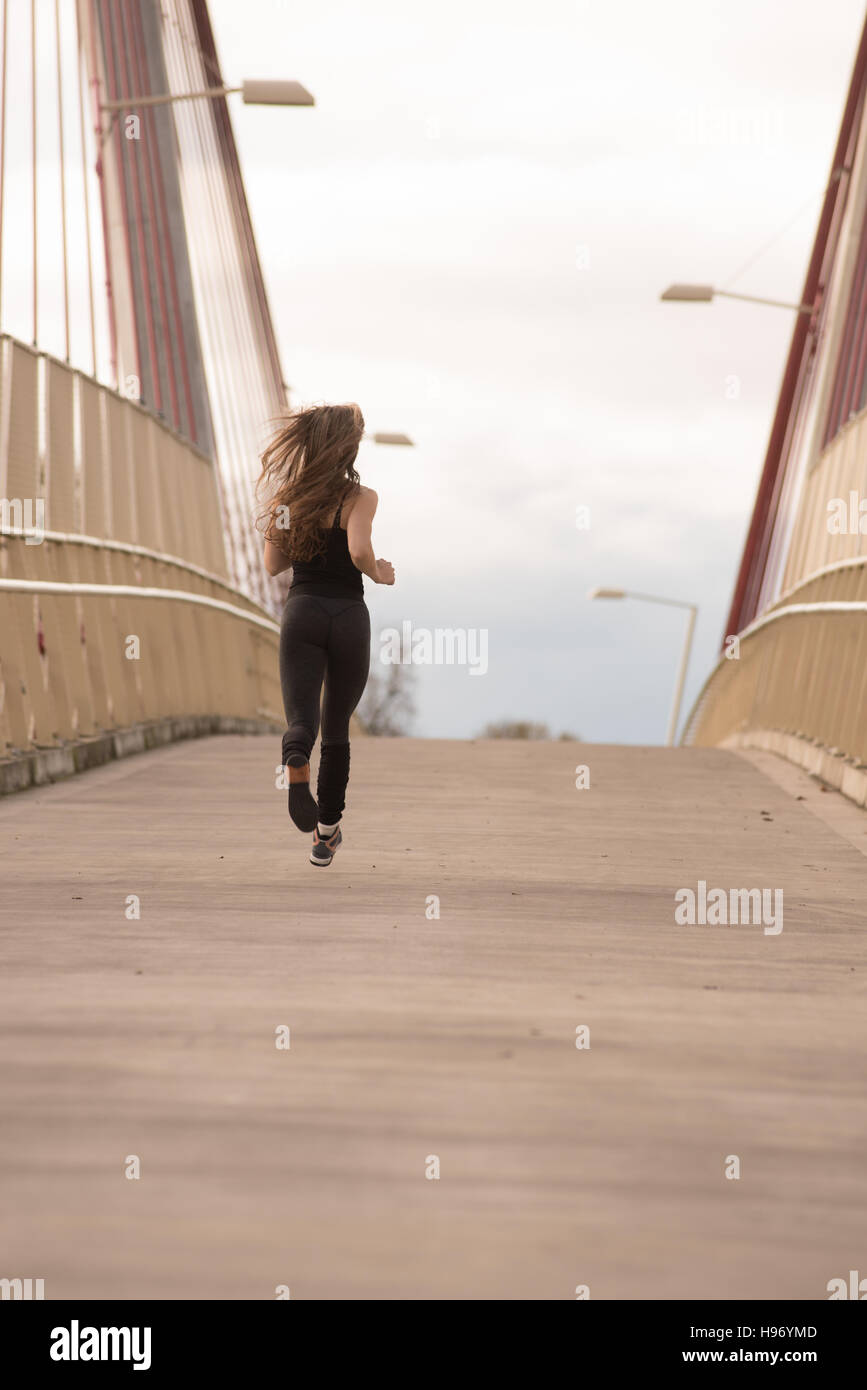 Athletic bella bionda calda in esecuzione su un ponte Foto Stock